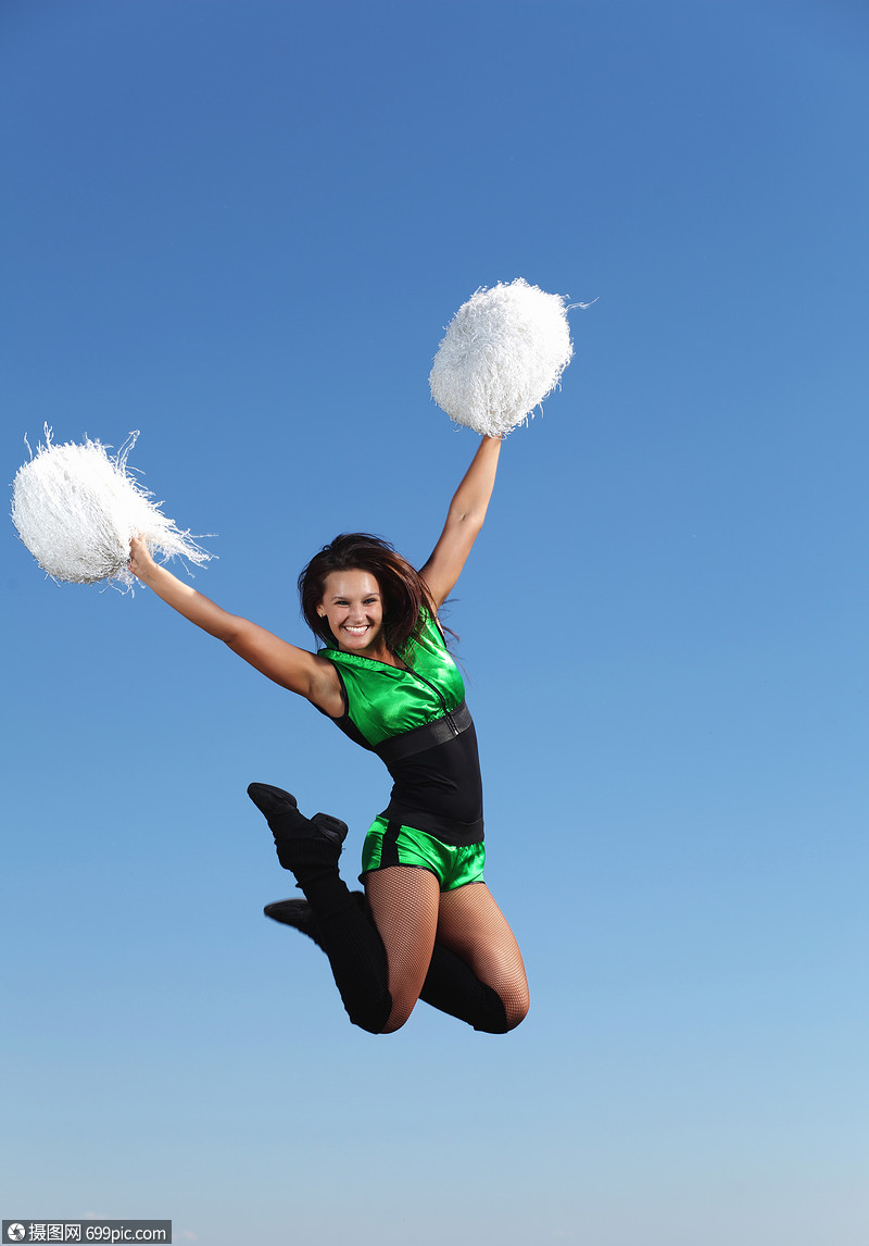 白色背景的轻女舞者穿着绿色服装的轻拉拉队长跳蓝天上体操霹雳舞
