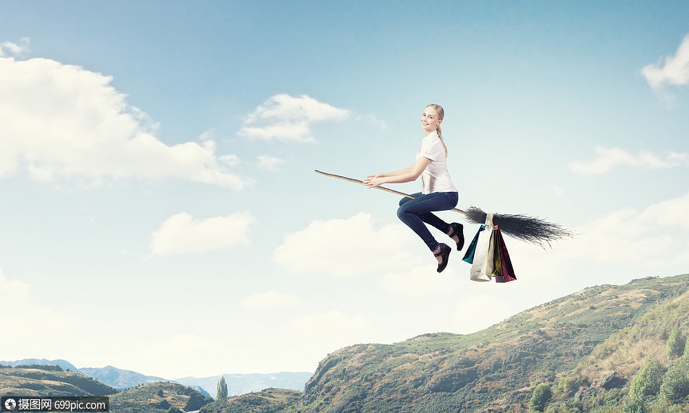 女孩乘扫帚飞快乐的轻女人扫帚上飞翔