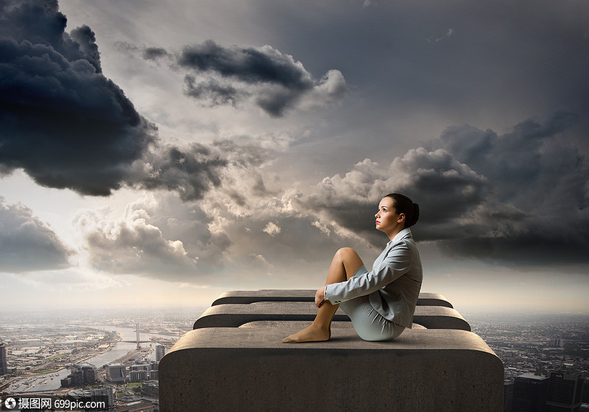 绝望中的女商人轻迷人的女商人独自坐大楼顶上的形象