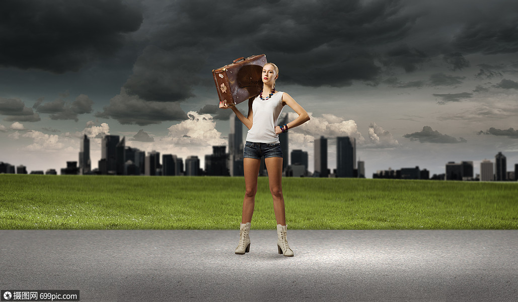 徒步旅行轻的女徒步旅行者肩上扛着手提箱走着路边乡村