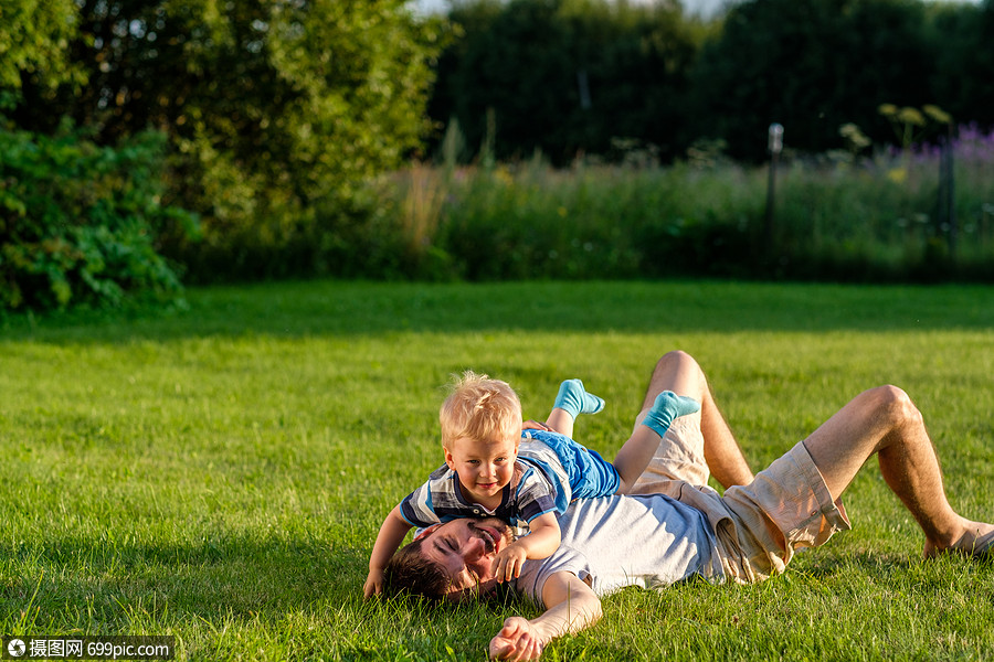 上玩得很开心父亲儿子公园的绿草地上休息的家庭生活方式场景小孩草坪