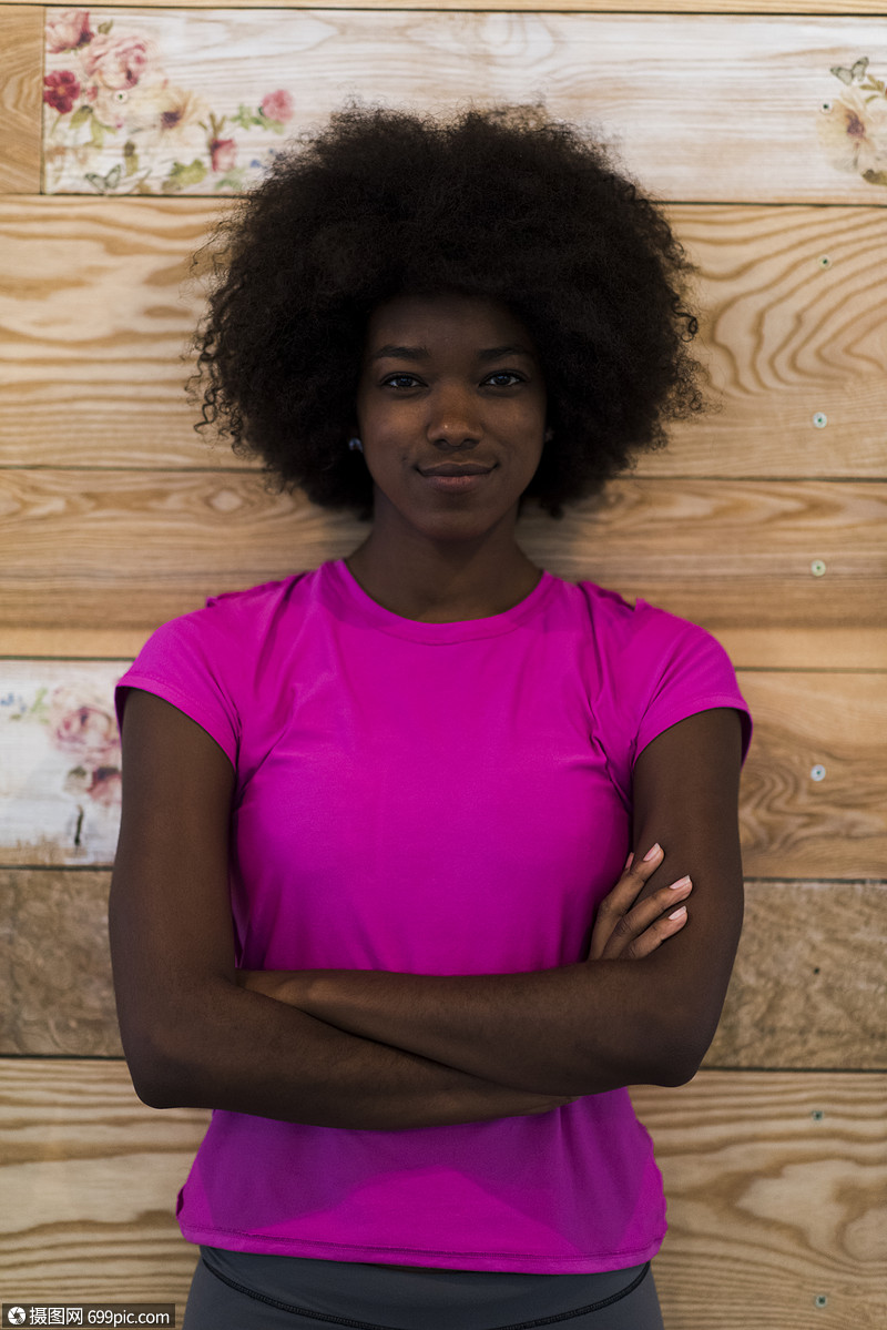 可爱的非裔美国妇女的肖像与afro发型,同时摆旧的复古木制背景