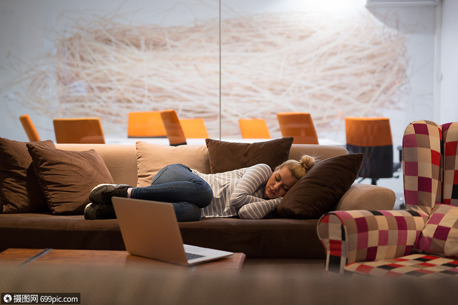 位轻的休闲商务女,创意办公室休息时睡沙发上成人经理