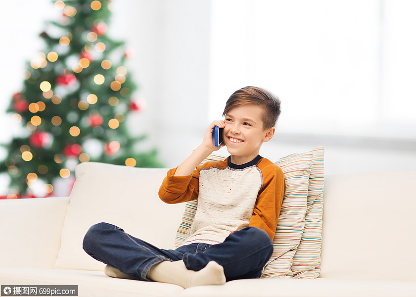 孩子,技术,沟通人的微笑男孩打电话家里的智能手机诞树背景诞节男孩家