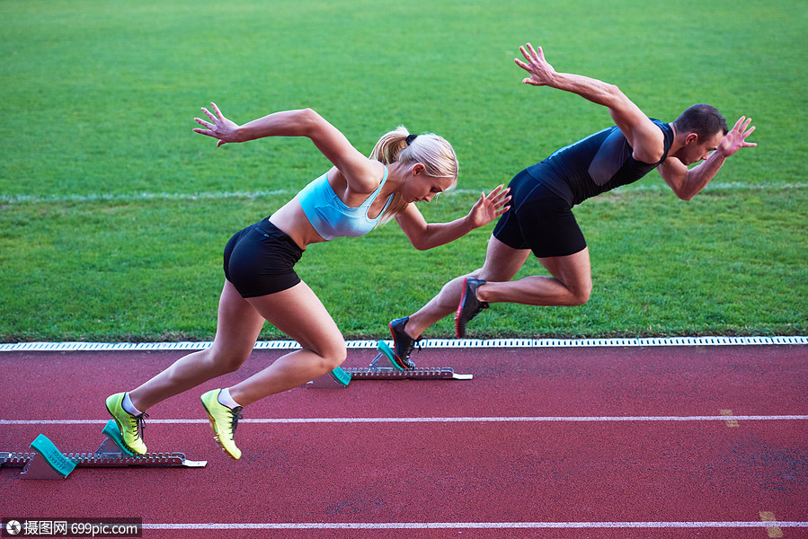 运动员女子体足球场上的田径跑道上跑步,代表体育中的竞争领导理念