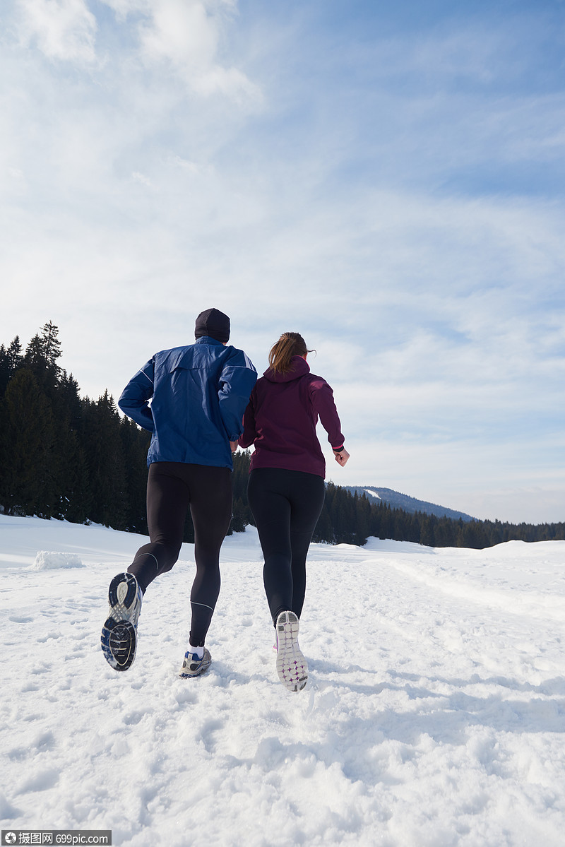 健康的轻夫妇森林里的雪地上慢跑运动员阳光明媚的冬日跑步