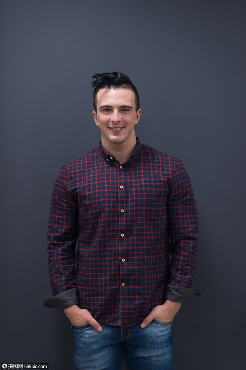 穿着休闲服装的轻商人的肖像,背景为灰色墙