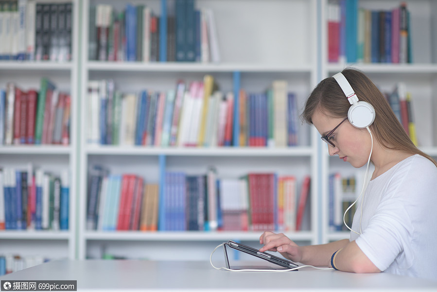 用平板电脑并互联网上搜索信息白色耳机上听音乐上课