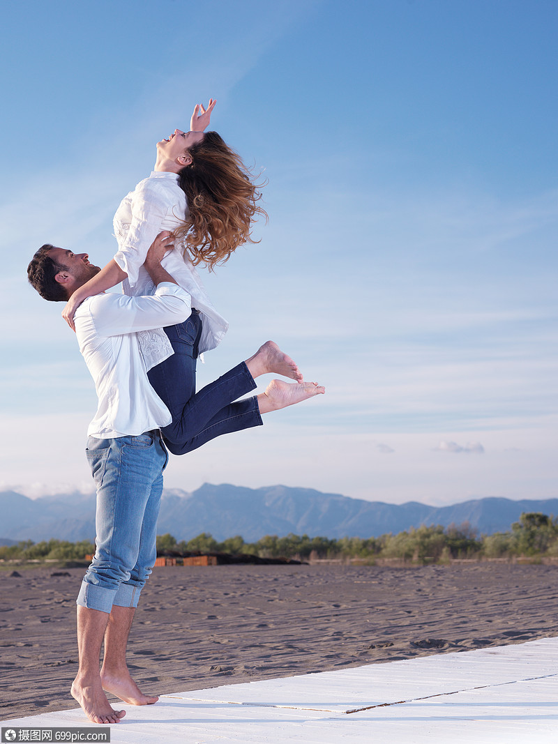 快乐的轻浪漫情侣美丽的夏日美丽的海滩上玩得开心