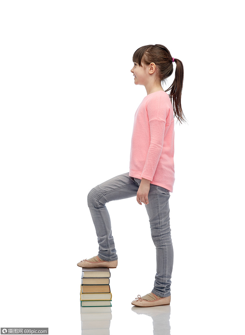 童,学校,教育人的快乐的小女孩踩书堆上可爱的漂亮的