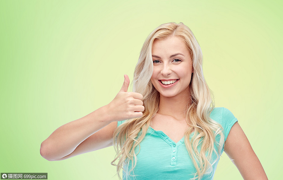 几岁的女孩绿色的自然背景下竖大拇指快乐的女人十几岁的女孩竖大拇指