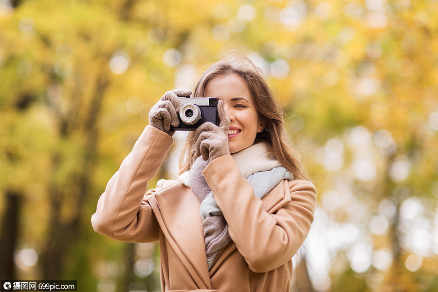 季节,摄影人的美丽的快乐的轻女人秋天公园用老式相机拍照