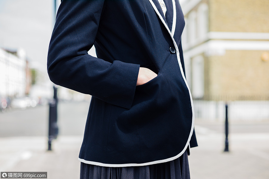 个轻的女人站街上,只手插口袋里女的行走