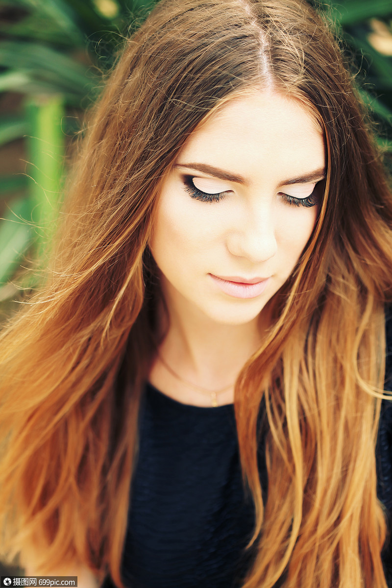 肖像特写轻美丽的女人,绿色背景下的夏季自然美丽的女孩,头发浓密,脸