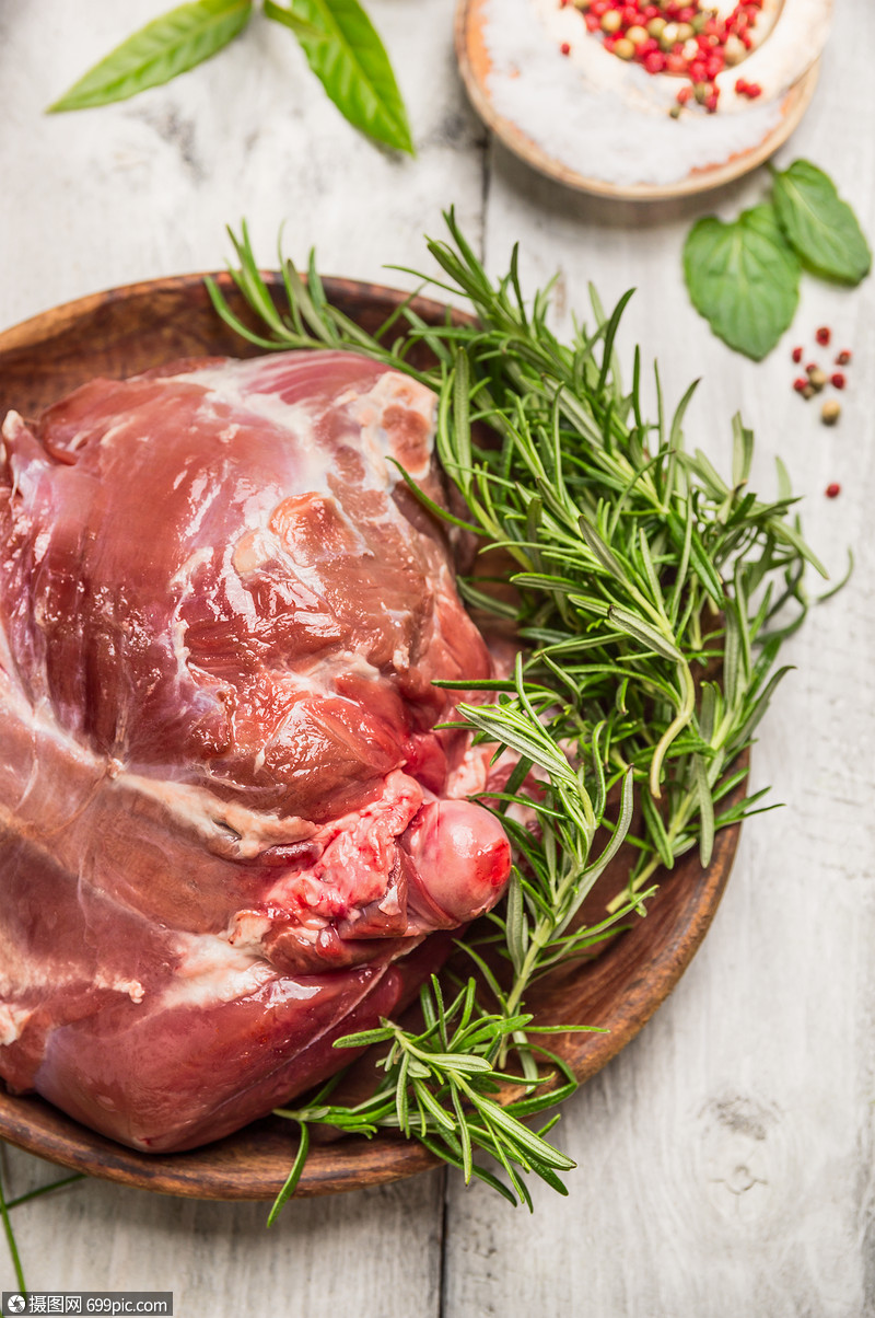 生腿羊肉木盘与迷迭香胡椒乡村背景