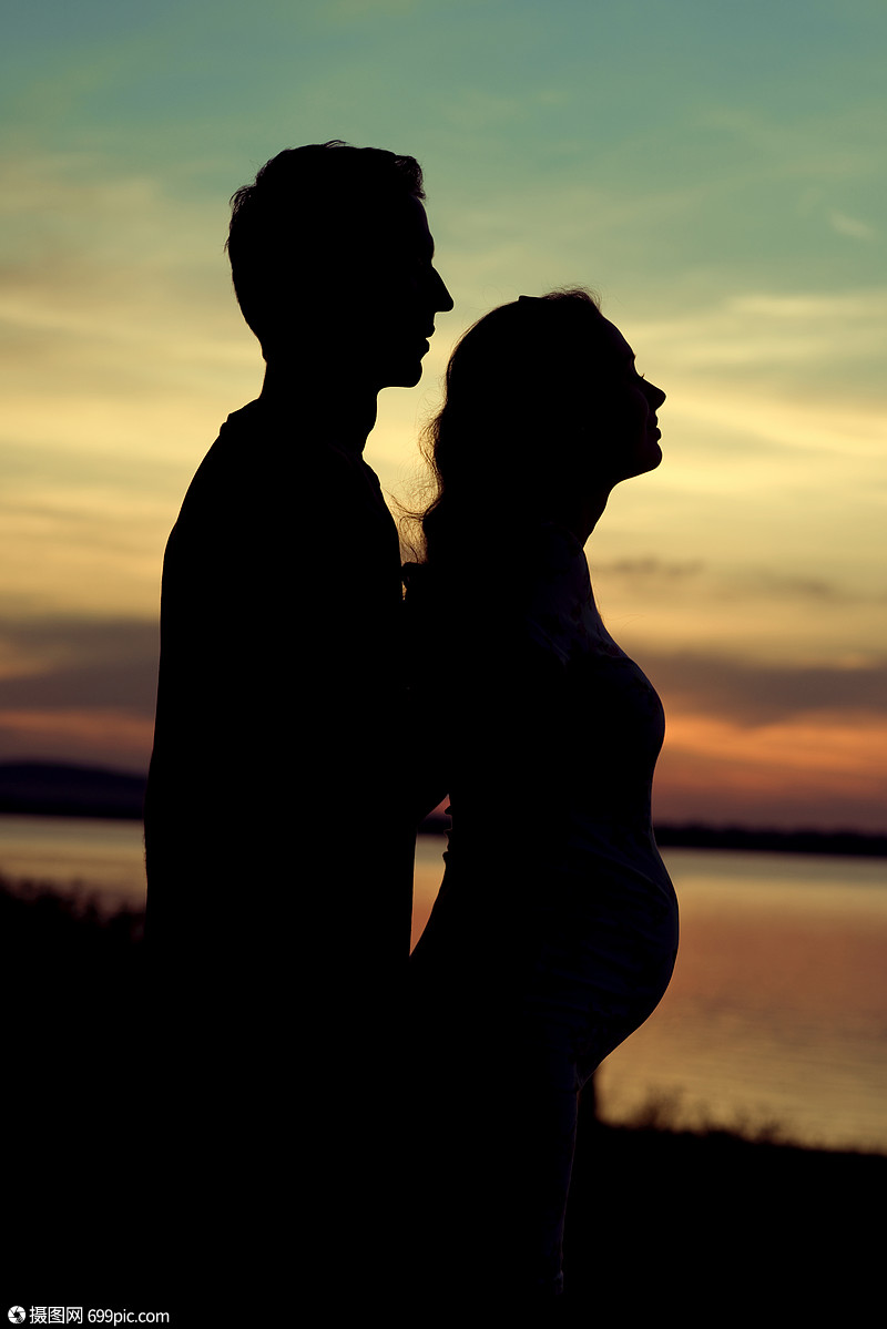 拥抱他怀孕女友的男人的剪影幸福的室内