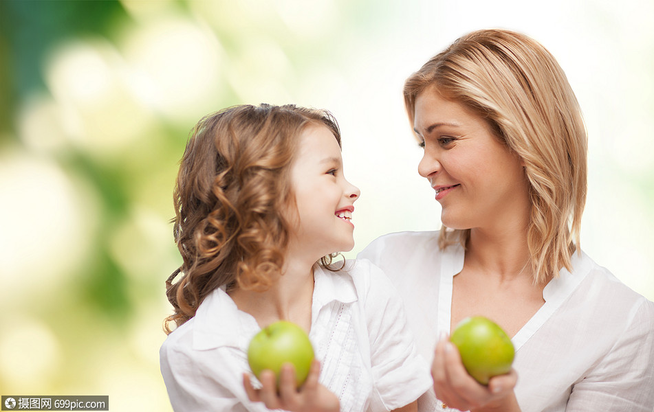 人,家庭,健康的饮食育儿观念快乐的母亲女儿与苹果超过绿色背景