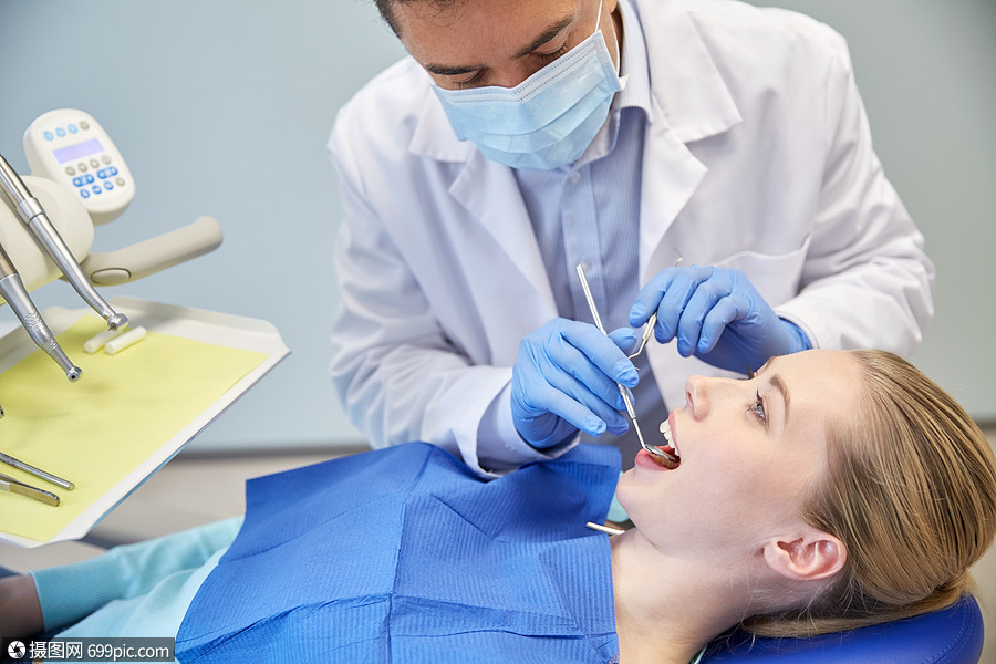 人,医学,口腔医学保健男牙医具上戴着牙科镜,并牙科诊所办公室检查女
