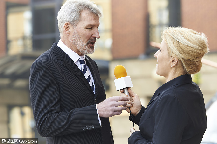 摄影师录制女记者采访商人