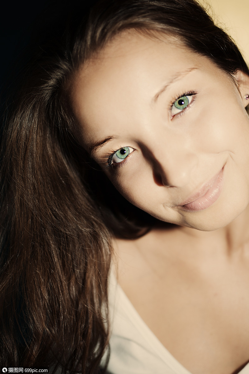 位美丽的轻黑发女人的肖像,绿色的眼睛摆姿势室内