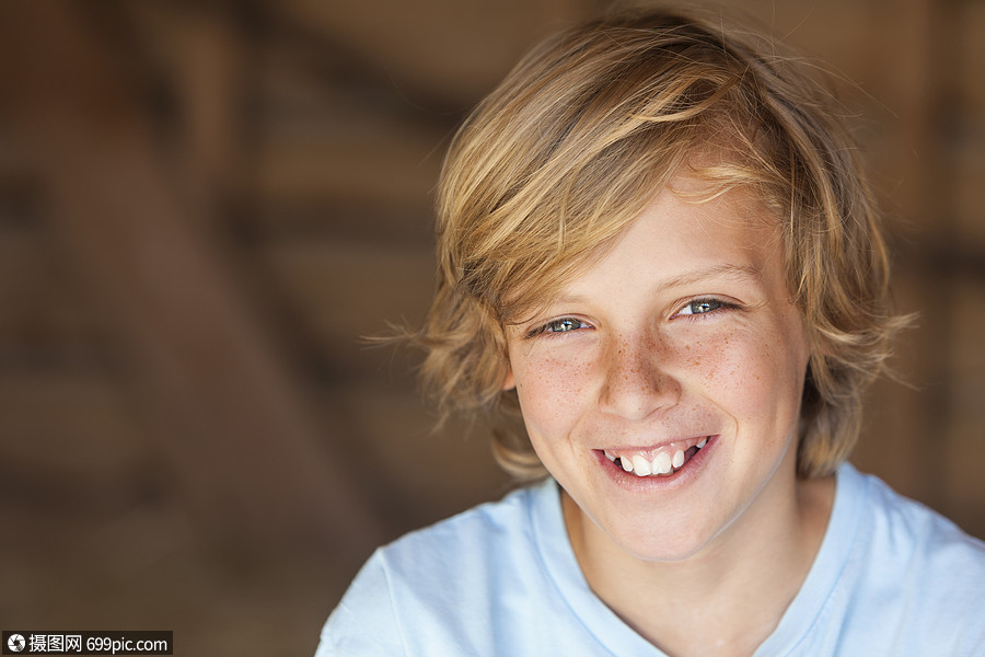 轻快乐微笑的金发男孩,大约12岁早期青少