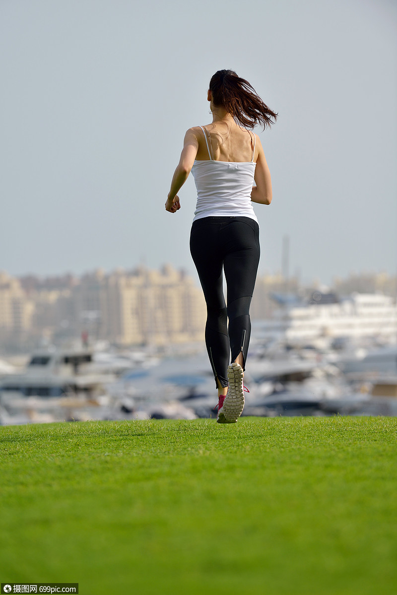 城市公园跑步早上外慢跑的女子跑步者,背景迪拜城市的场景