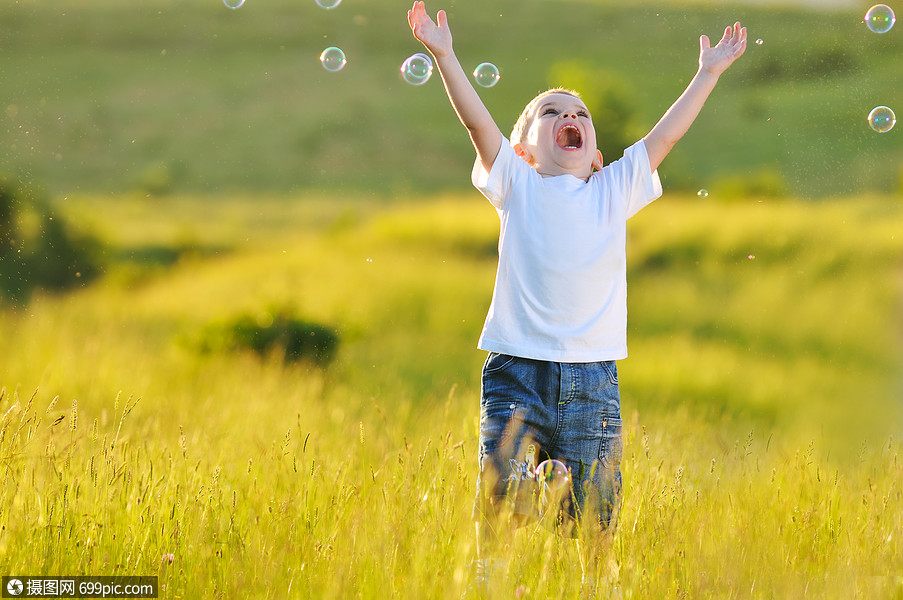摄图网>照片>外国人像>快乐的轻美丽的孩子eadow上玩肥皂泡泡玩具.