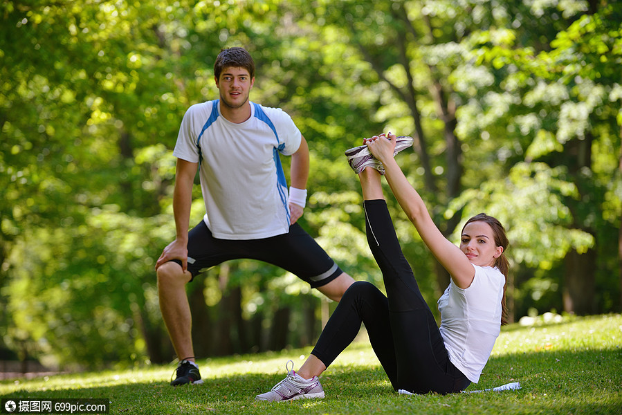 轻的健康夫妇伸展运动,放松热身后,慢跑跑步公园拉伸青少
