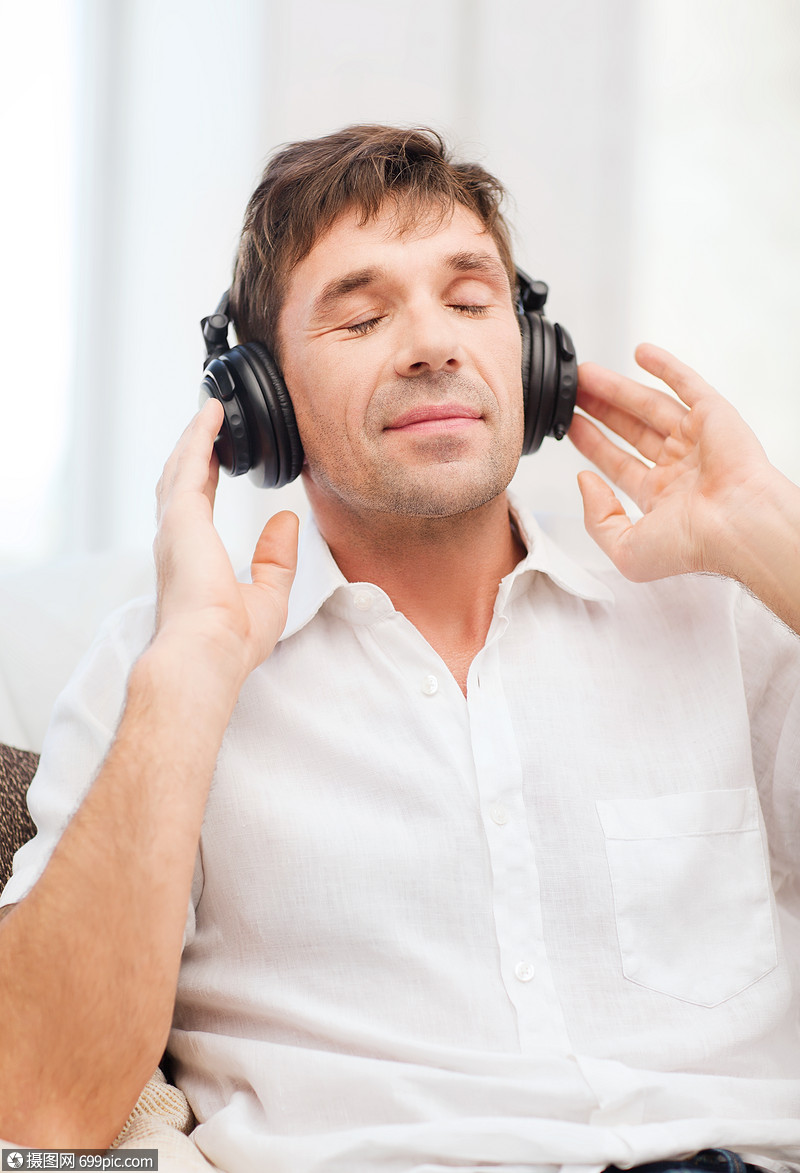 休闲生活方式的快乐的男人戴着耳机家听音乐