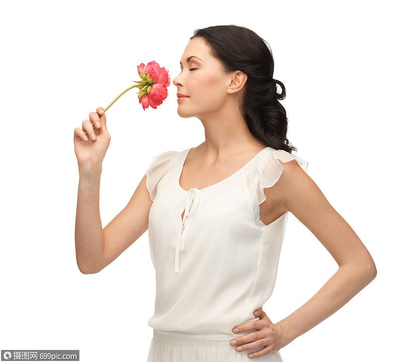 轻美丽的女人闻花的照片