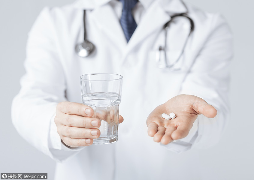 医生的手给白色药丸杯水的照片止痛药医学的