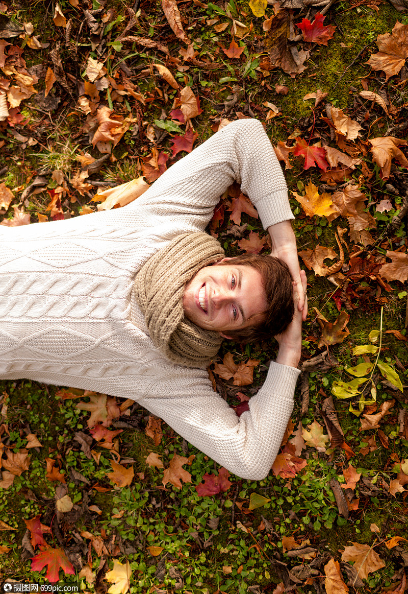 季节,幸福人的微笑的轻人躺地上草地秋天公园的落叶上