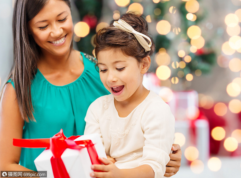 节日,庆祝,家庭人的快乐的母亲小女孩与礼品盒客厅诞树背景