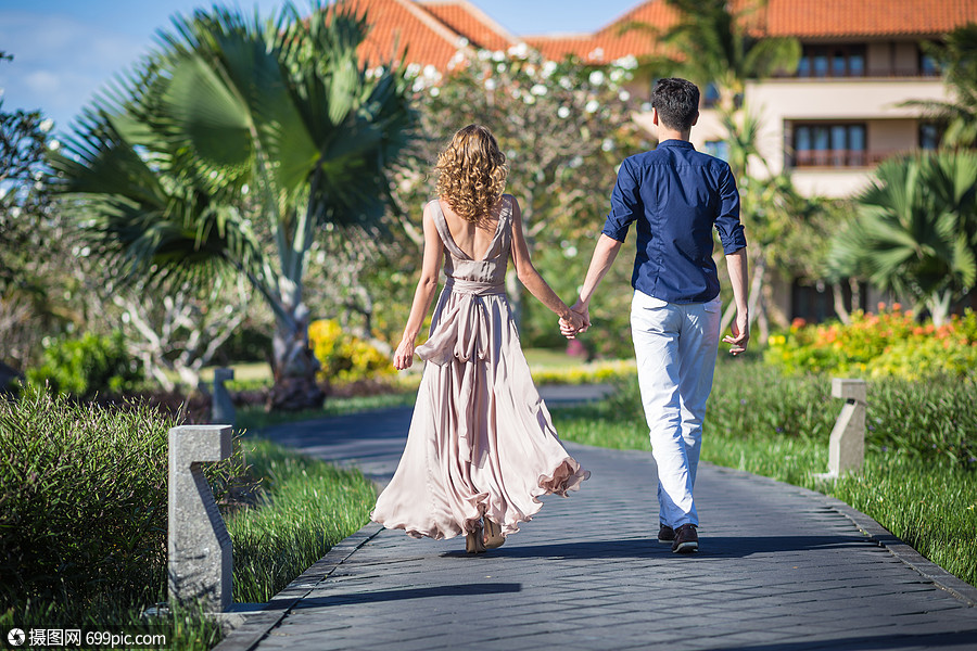 幸福的轻夫妇个绿色的公园里散步