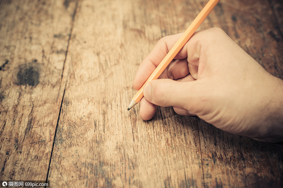 个男人的手用铅笔写字左边拇指