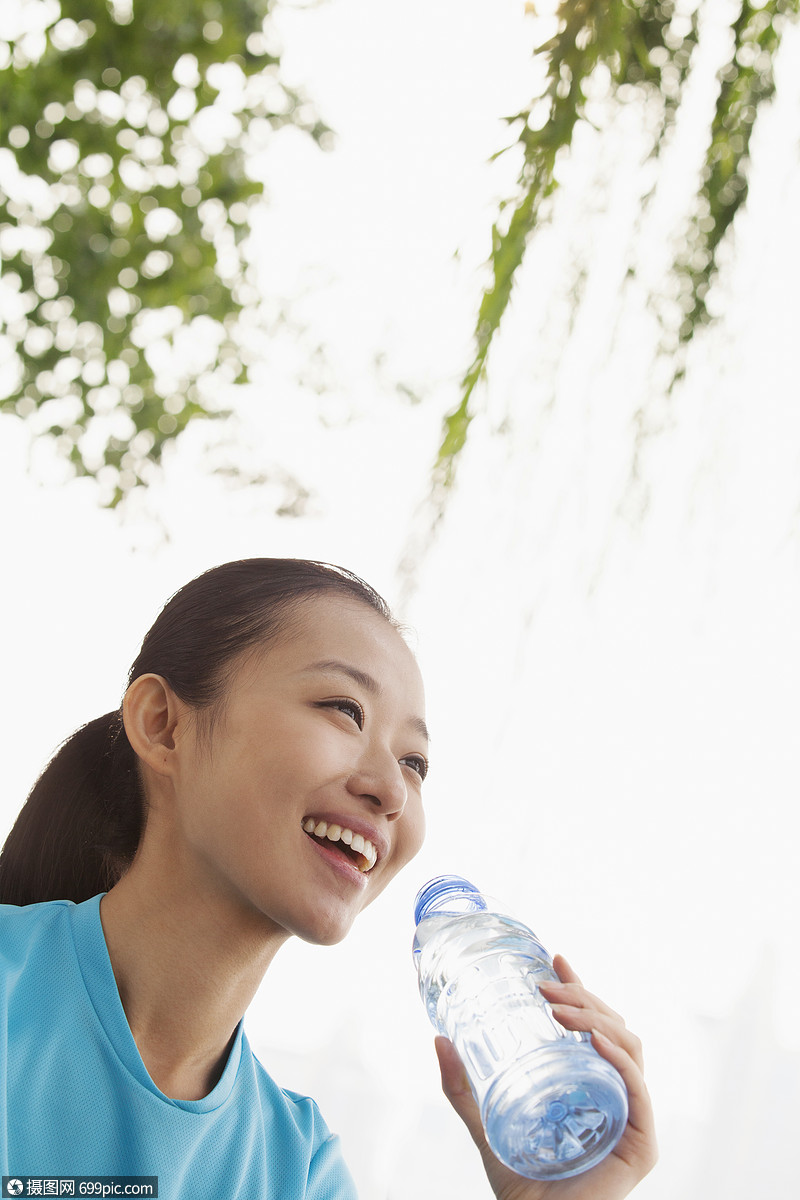 轻的女人喝水微笑边