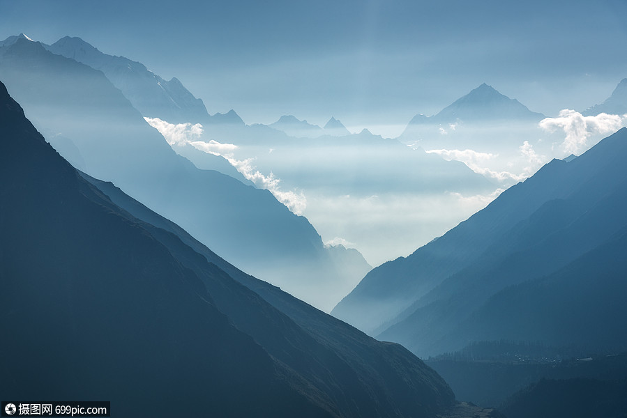 尼泊爾日落時群山低雲輪廓的雄偉景色喜馬拉雅山的高岩石,美麗的藍天