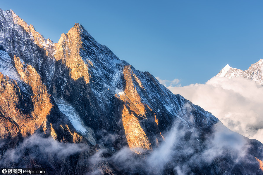 庄严的场景与阳光明媚的山峰尼泊尔的云风景优美,高岩石蓝天阳光明媚