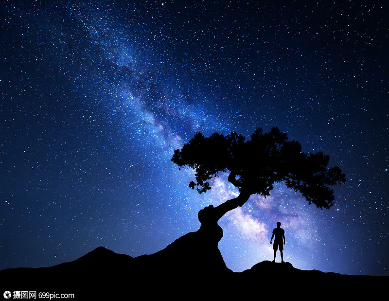 老树个独自站山上的人的轮廓蓝色的银河,光人旅行背景树下个人的剪