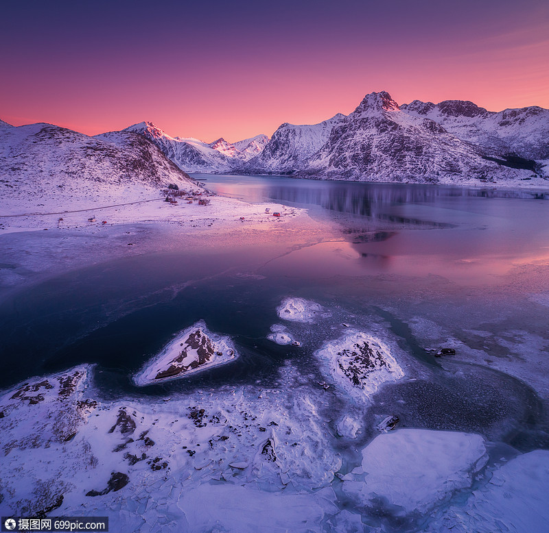 挪威洛福滕岛五颜六色的日落时,水紫色的天空中反射冬天的风景雪覆盖