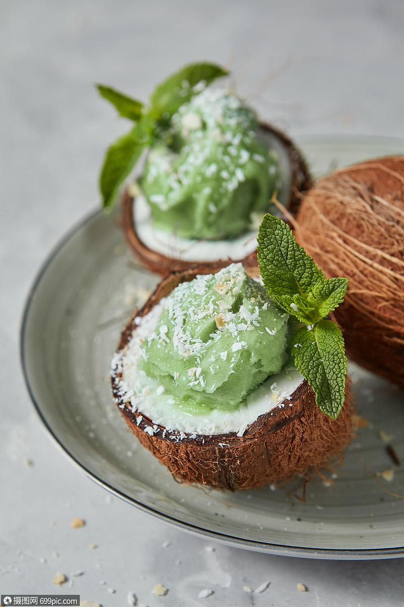 椰子与绿色冷冻薄荷甜点,绿色薄荷个盘子上的灰色背景素食的夏季食品