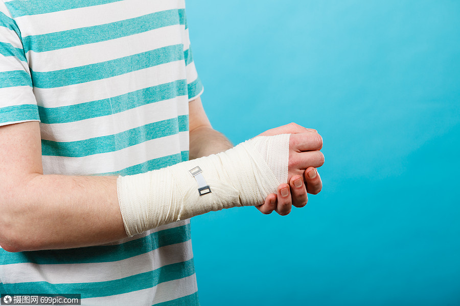 疼痛伤害的轻人握着绷带的手身体受伤的部分医学医疗保健用痛苦绷带的