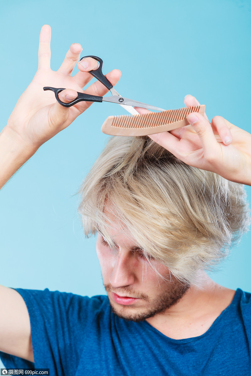 风格时尚轻时尚的男发型师理发师新的想法,改变外观金发男人用剪刀