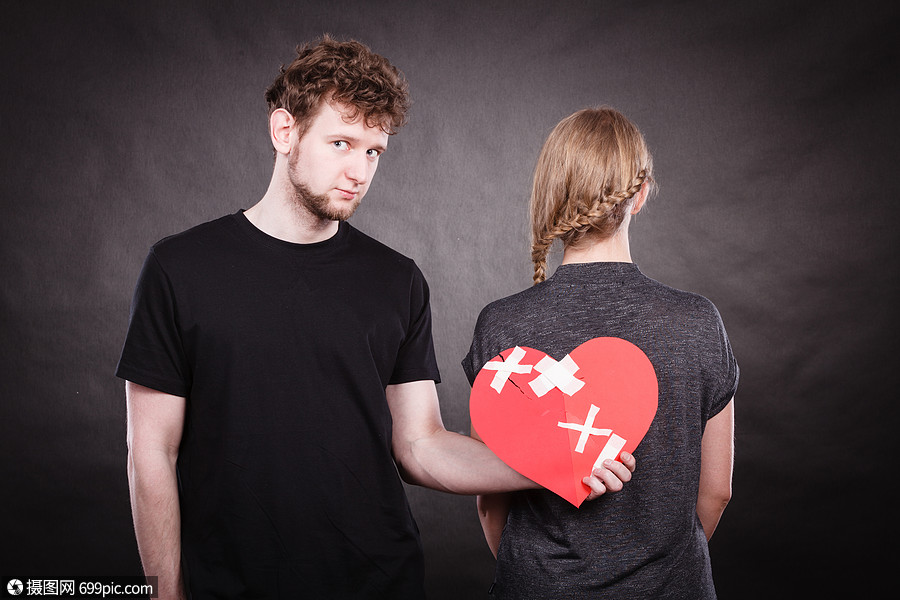 女人男人着纸,红心用石膏绷带固定感情上的裂痕悲伤的夫妇抱着破碎的