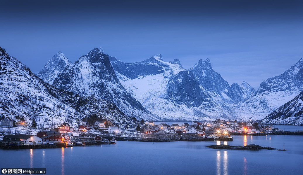 蓝色多云的天空冬天的夜晚反射水中风景与美丽的雷恩卢福滕岛,挪威
