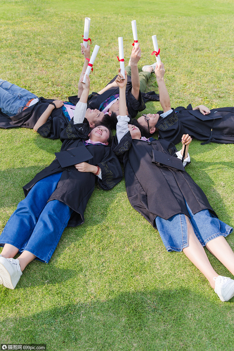 毕业季大学生们躺草地举着证书