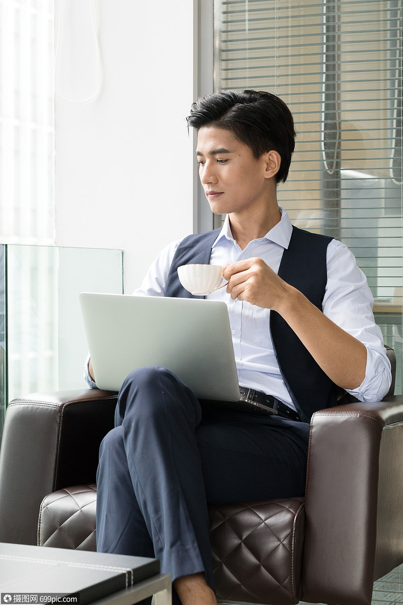 年轻商务男士落地窗前喝咖啡加班互联网