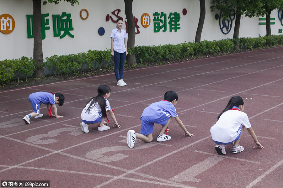 男女同學在操場跑道上比賽跑步起點活力