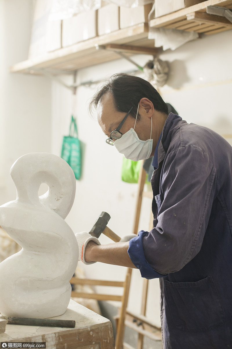 专注的石匠雕刻师傅在雕刻作品