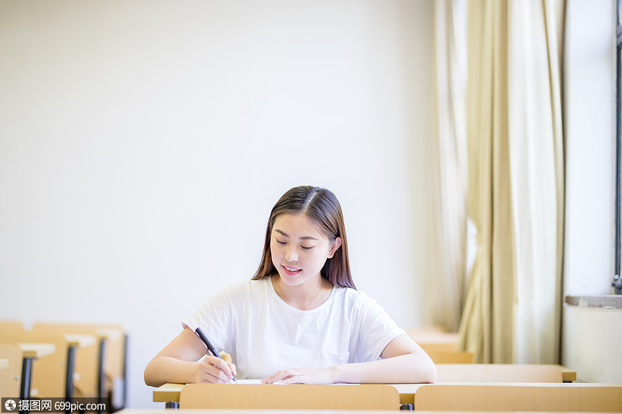 教室裡自習學習寫字的女大學生書寫女同學